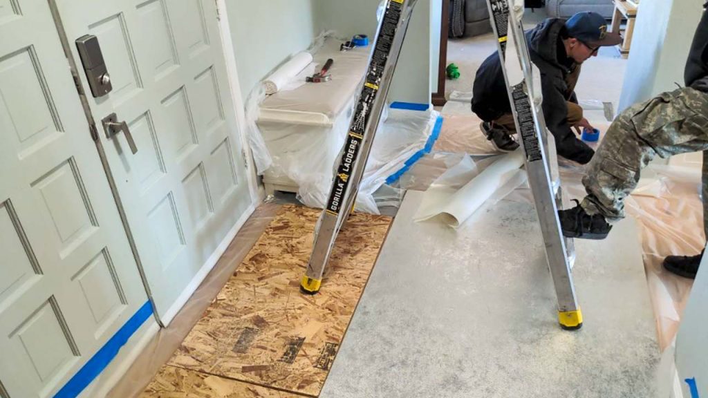 Protecting your home with plywood and plastic sheeting.